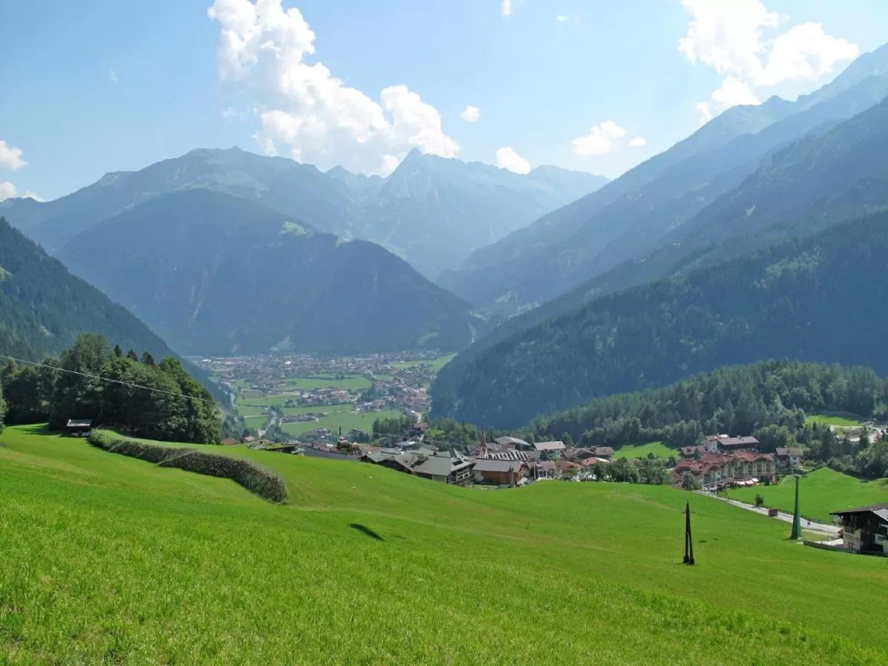 Ein Tal mit einer kleinen Stadt, umgeben von Bergen.
