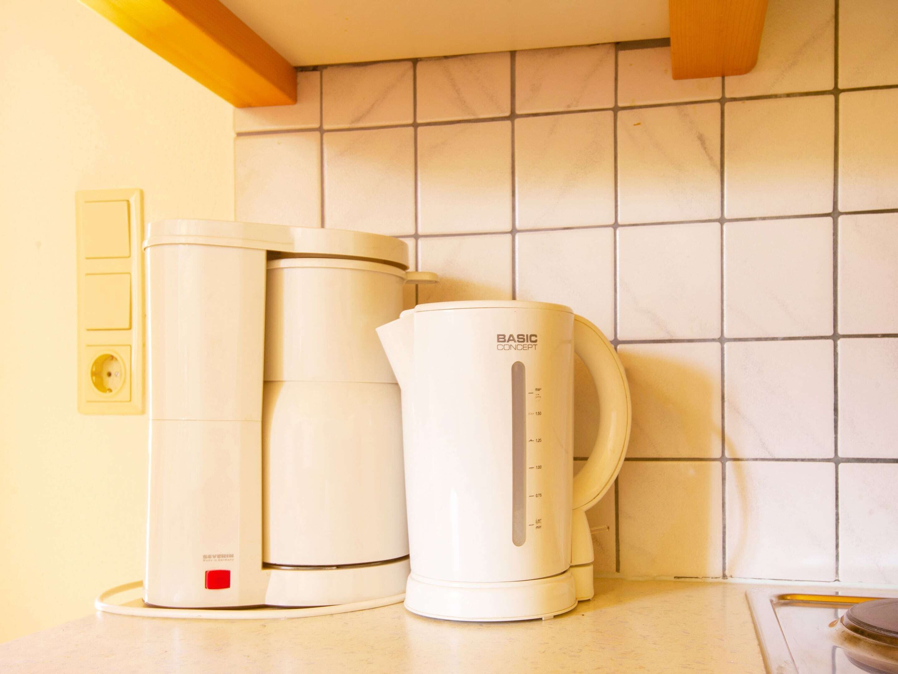 Eine Küche mit Kaffeemaschine und Wasserkocher auf der Arbeitsfläche.