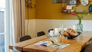 A dining table with a magazine, a bottle of juice, and a loaf of bread. - Holiday Home in Baarlo With Wood-fired Hot Tub (Baarlo)