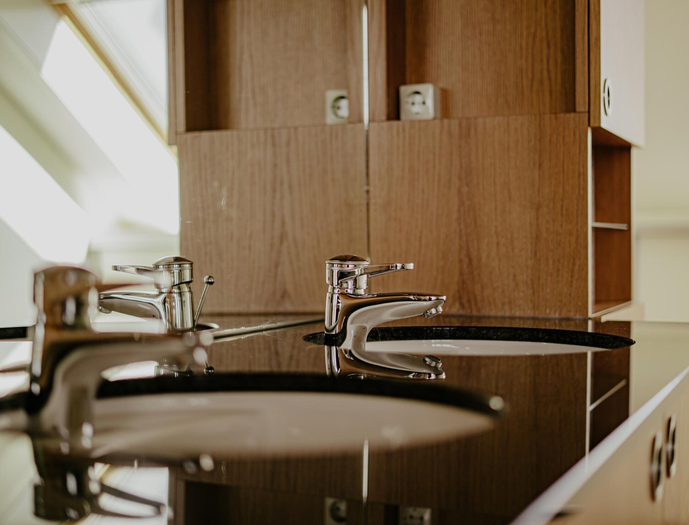 A kitchen with a modern design, featuring stainless steel appliances and wooden cabinetry.