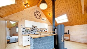A spacious loft with a kitchen, a stone fireplace, and a large clock on the wall. - Charming Holiday Home in Stavelot With a Garden (Stavelot)