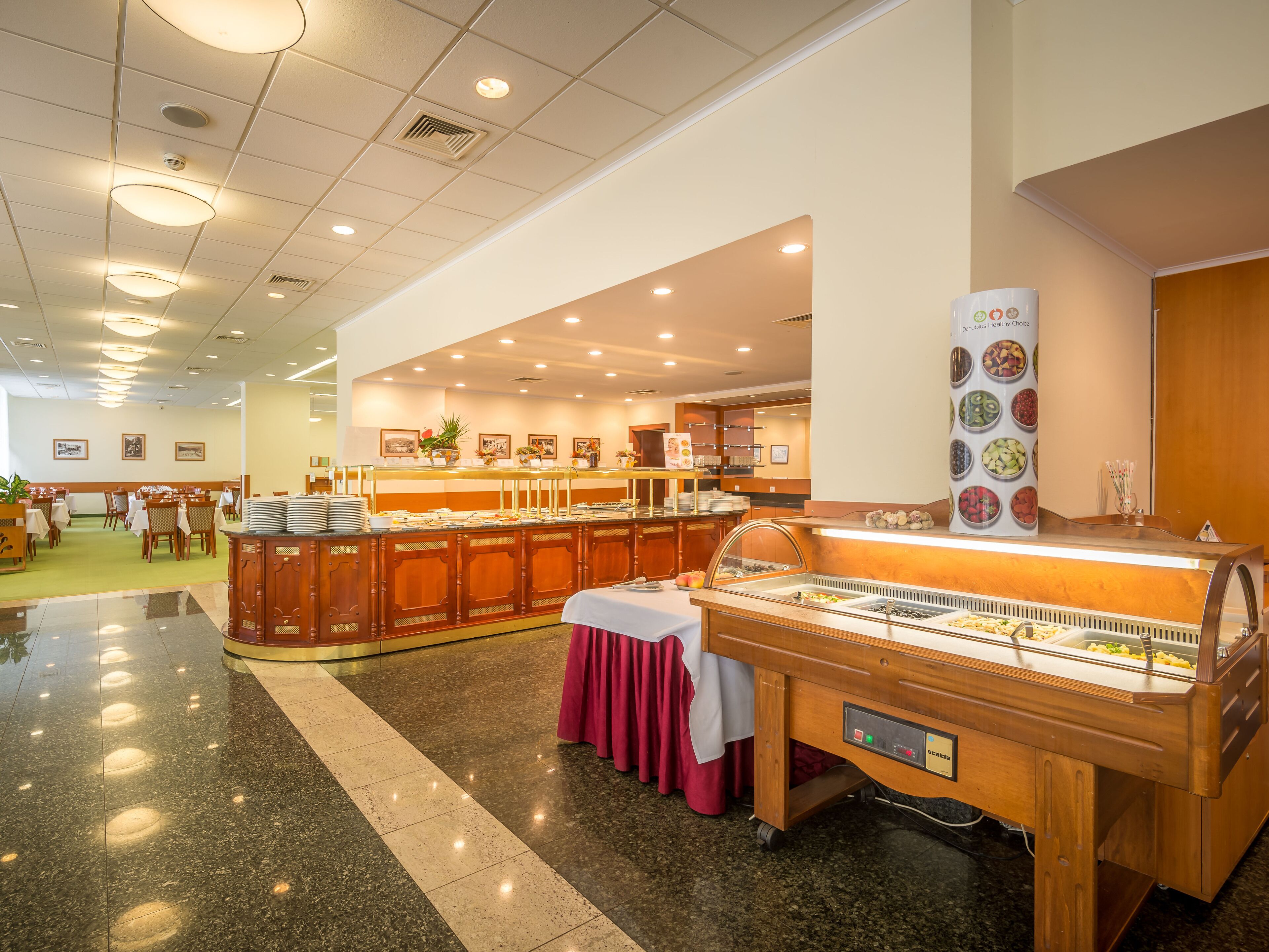 Montaje tipo bufé con varias estaciones de comida, una zona de recepción y un interior limpio y bien iluminado.