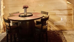 Una escalera de madera con una mesa y sillas en una cabaña.