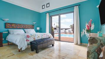 Un dormitorio con cama, una banca, un ventanal y vistas al exterior.