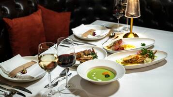 A dining table set with various dishes, wine glasses, and a lamp.