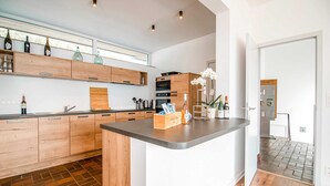 A modern kitchen with wooden cabinets, a central island, and a variety of kitchen appliances. - Holiday Home in HUY Near Town Center (Wanze)