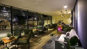 En modern inredning med en sittgrupp, en soffa, ett soffbord och en bokhylla.