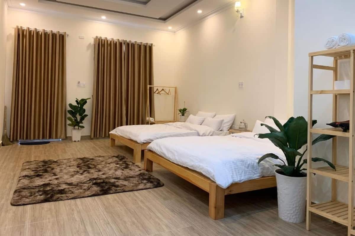 A modern bedroom with two wooden beds, a large fluffy rug, and a wooden shelf unit.