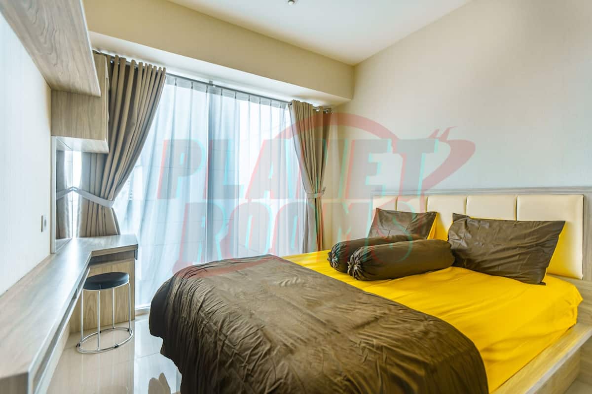 Une chambre d’hôtel avec un lit, un bureau et une fenêtre avec des rideaux.