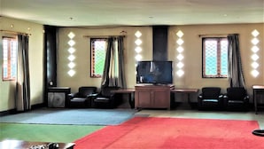 A room with a television, seating area, and windows with curtains. - Villa Orange Lembang Pengkolan (Lembang)
