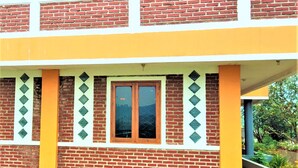 A two-story building with a brick facade and a yellow and white color scheme. - Villa Orange Lembang Pengkolan (Lembang)