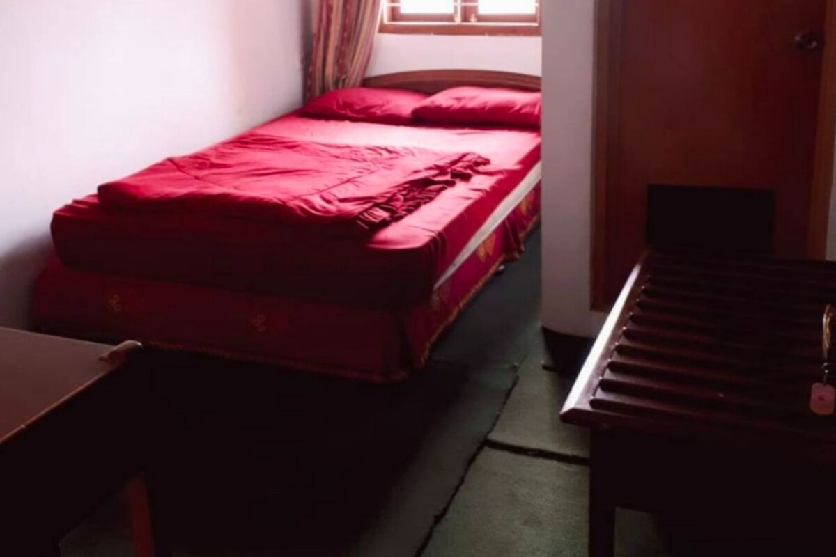 A small room with a bed, a desk, a chair, and a piano.