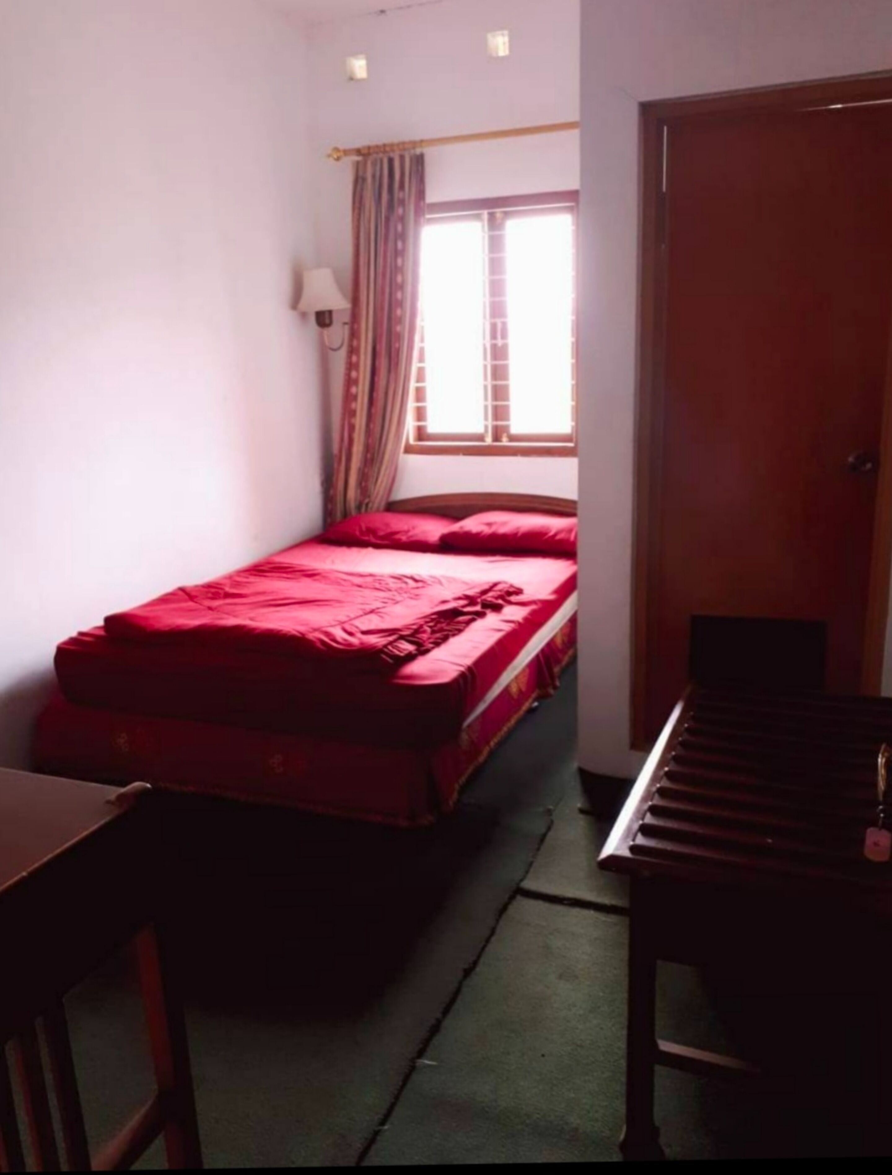 A small room with a bed, a desk, a chair, and a piano.