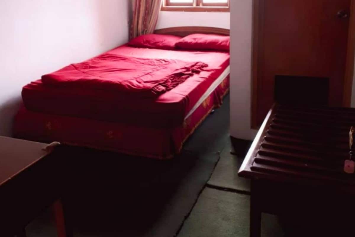 Une petite pièce comprenant un lit, un bureau, une chaise et un piano.