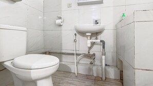 Une salle de bain avec des toilettes, un lavabo et une douche.