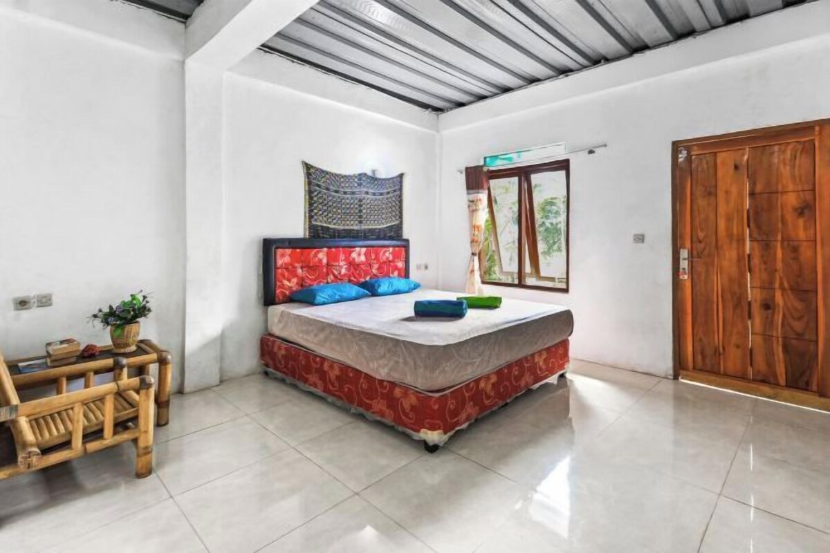 Un dormitorio con cama, una puerta de madera y una ventana.