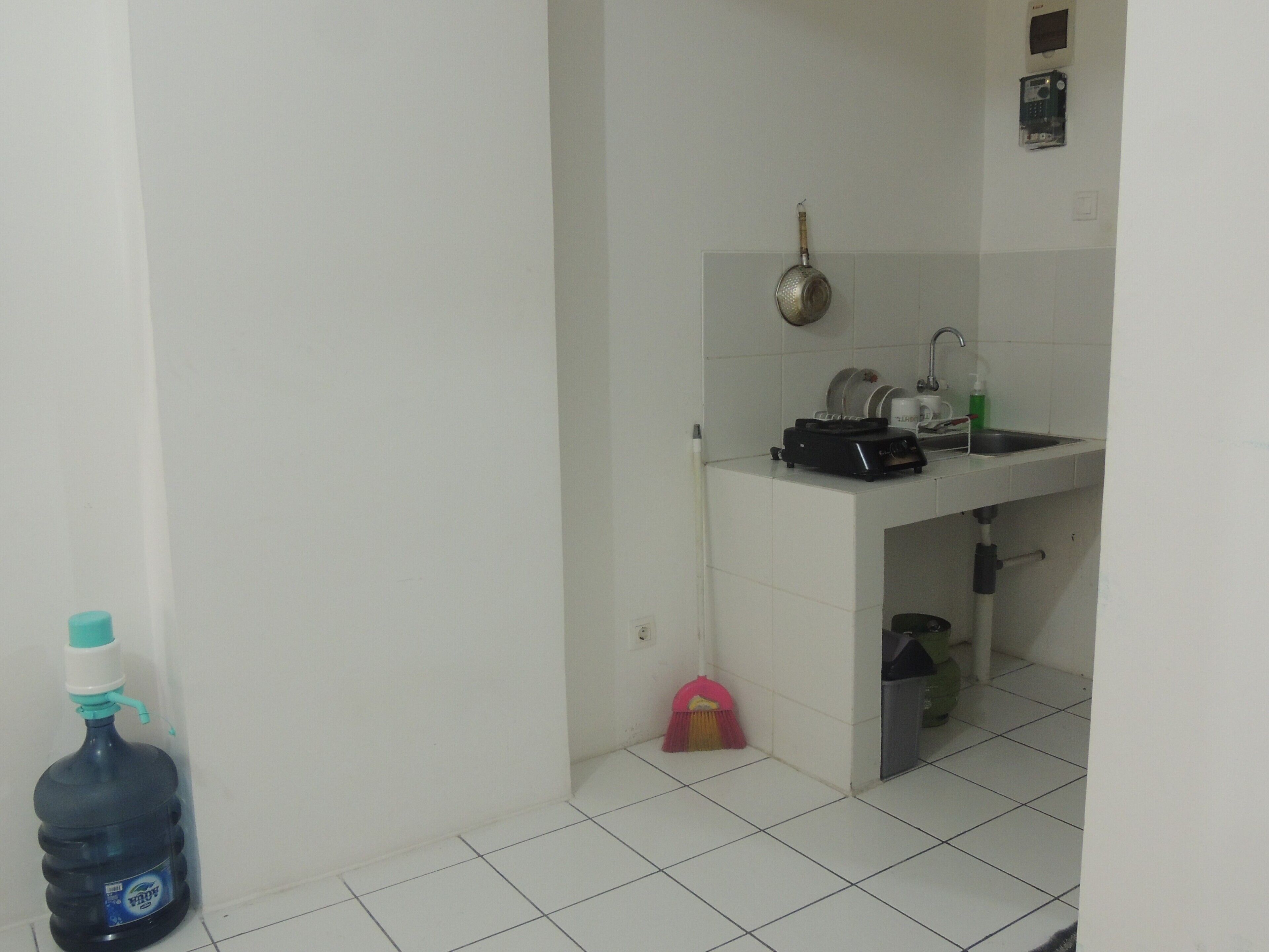 Uma cozinha compacta com pia, esfregão e bebedouro.