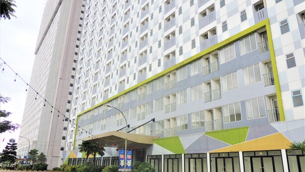 Un hotel de varios pisos con fachada moderna, que presenta un diseño geométrico de ventanas y balcones.