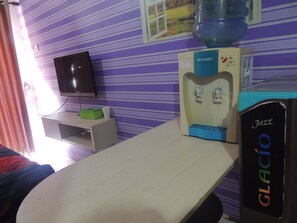 Relax in this inviting space with a flat-screen TV, a water dispenser, and a comfortable bed.