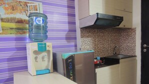 Une cuisine équipée d’un distributeur d’eau, d’un réfrigérateur et d’un crédence carrelée.