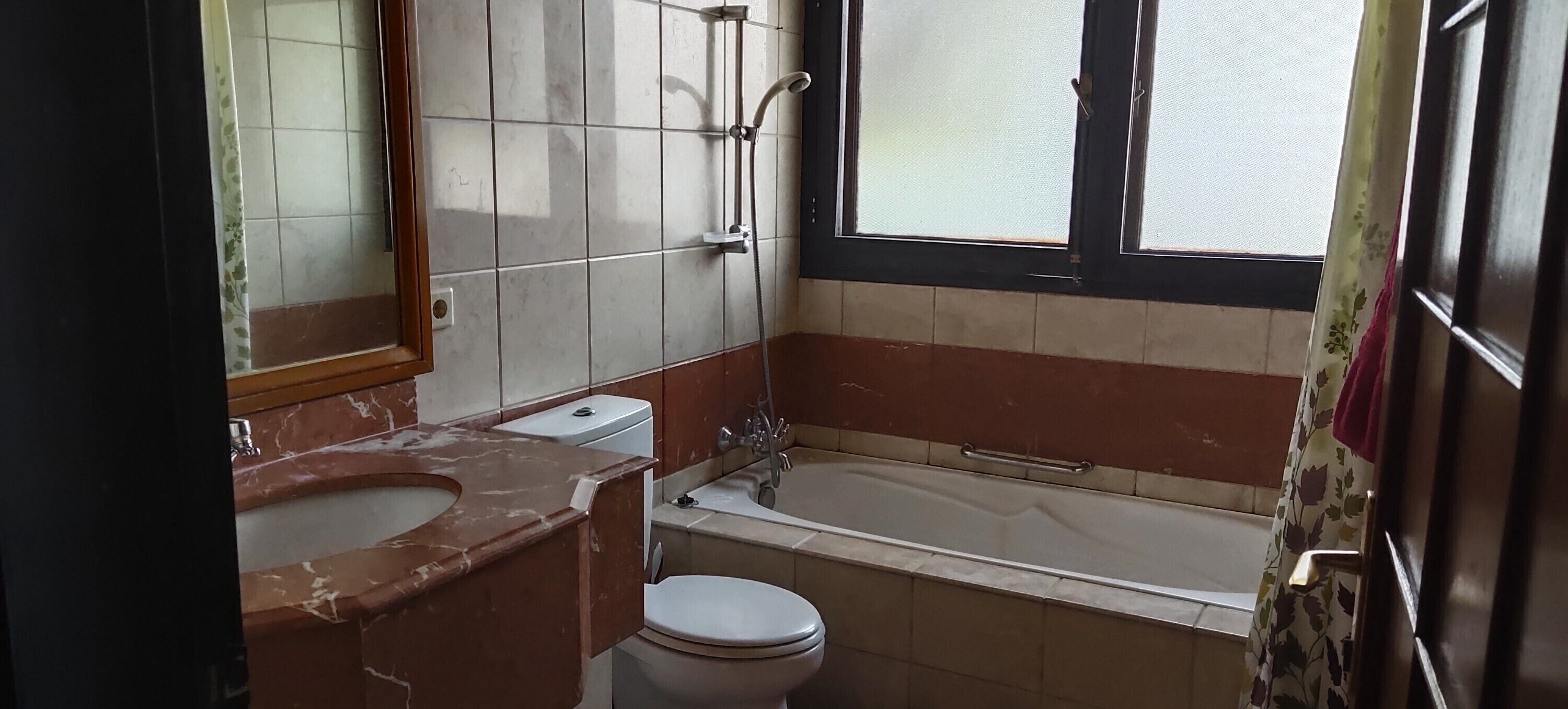 A bathroom with a toilet, sink, and bathtub.