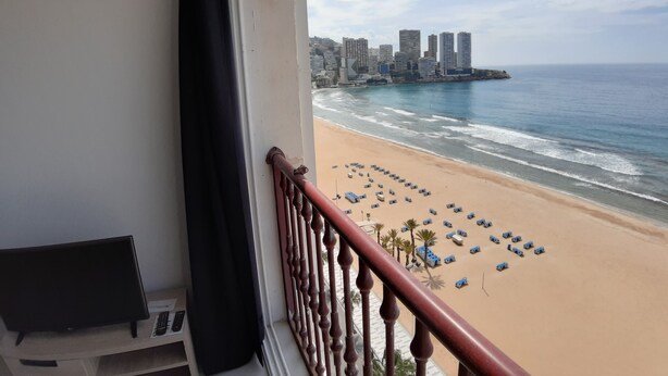 Uma varanda com vista para a praia, o horizonte urbano e o oceano.