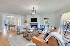 A spacious living room with a fireplace, a pool table, and a comfortable seating area. - Hill Country Escape | Pool, Hot Tub & Sleeps 25 (Austin)