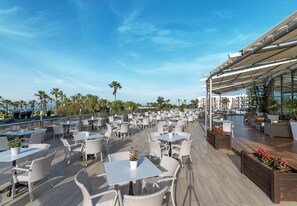 A rooftop terrace with outdoor seating, palm trees, and a view of the ocean. - Kaya Side Hotel (Manavgat)