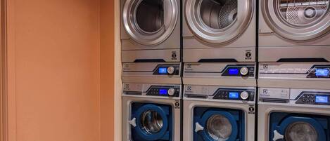 A row of Electrolux washing machines with digital controls and a safety lock.