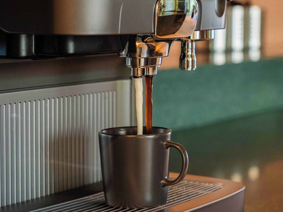 En kaffemaskin som häller upp kaffe i en kopp.