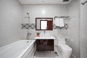 Une salle de bain moderne équipée d’une baignoire, de toilettes, d’un lavabo et d’une douche.
