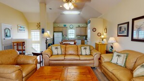 A cozy living room with a leather sofa set, a wooden coffee table, and a kitchen in the background. - FH4, Near Beach, Shared Pool, Golf Cart Access (Port Aransas)