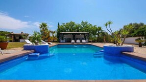 A swimming pool with a tiled deck, lounge chairs, and a covered seating area. - Dream finca: XXL pool, table tennis, BBQ house, volleyball, air-condition (Port de Pollença)