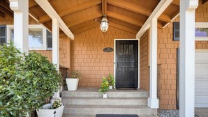 A covered porch with a wooden ceiling and a black door. There are steps leading up to the door, and a potted plant is placed on the steps. - 5 Bedroom wine Country Home, Grill, Hot Tub, Granny unit in Santa Rosa  (Santa Rosa)