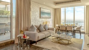 A modern living room with a sofa, coffee table, and dining area.