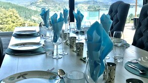 Une table dressée pour le dîner, avec une vue panoramique sur les montagnes en arrière-plan.