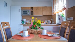A dining table with placemats, white cups, and a centerpiece with flowers. - 4****Sterne Spatzennest 86 sqm between Augsburg and Ulm quietly located new building (Burtenbach)