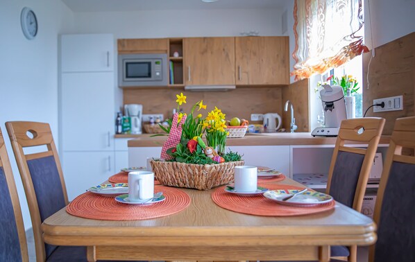 Une table à manger avec des sets de table, des tasses blanches et un centre de table décoré de fleurs.