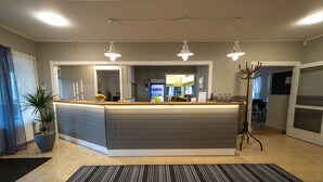 A modern kitchen with a central island, pendant lighting, and a potted plant. - Lövudden Strand (Vasteras)