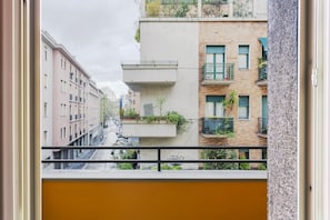 A view from a balcony overlooking a row of multi-story buildings with balconies and windows.