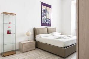 A modern bedroom with a bed, bedside table, and a glass cabinet. - Hostmate - Milano - Via Pacini- Lambrate (Milano)