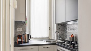 A modern kitchen with a window, stainless steel appliances, and a tiled backsplash. - Hostmate - Milano - Filzi - Stazione Centrale (Milano)