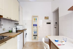 A compact kitchen with white cabinets, a microwave, a toaster, and a small sink.
