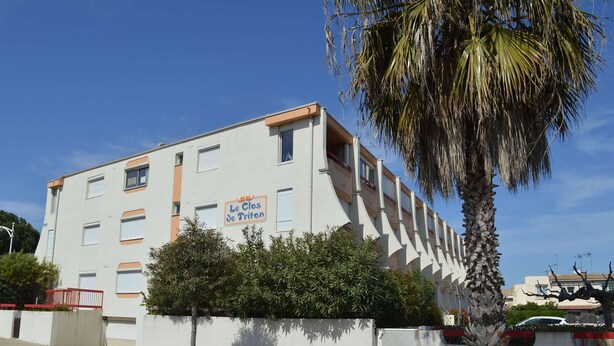 A multi-story building with a sign reading 'Le Clés de Triton.' - Air-Conditioned Studio 4 Ppl in Le Grau-du-Roi (Le Grau-du-Roi)