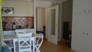 A compact living space with a kitchenette, a dining area, and a sofa. - Air-Conditioned Studio 4 Ppl in Le Grau-du-Roi (Le Grau-du-Roi)