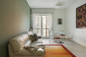 Un salon moderne comprenant un canapé, une table à manger, des chaises et des œuvres d’art accrochées aux murs.