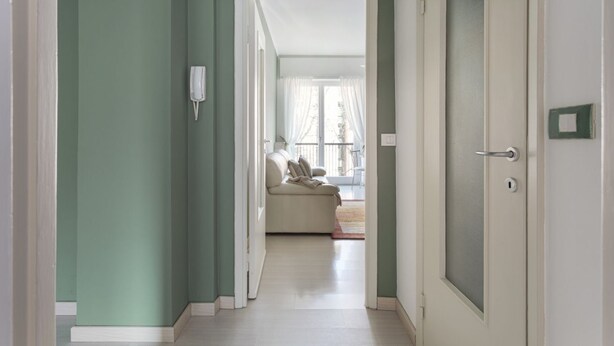A hallway leading to a living area with a sofa and a window. - Hostmate - Milano - Cenisio - Bullona (Milano)