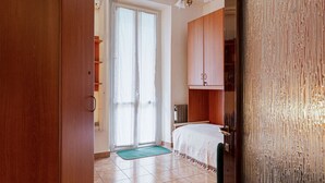 A bedroom with a bed, a wardrobe, a door, and a window. - Hostmate - Milano - Via Rovereto (Milano)