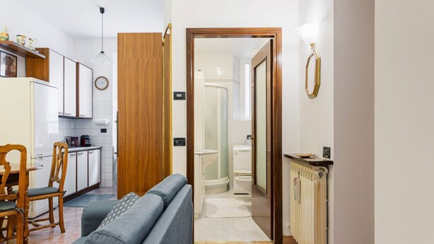 A compact living space with a kitchenette, a dining area, a sofa, and a bathroom. - Hostmate - Milano - Via Rovereto (Milano)