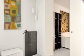 A hallway with a white wall, a geometric artwork, a black door, and a patterned wall. - Hostmate - Milano - Solferino - Brera (Milano)